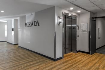 a room with a wall that says mirada and a metal elevator